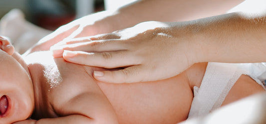 Baby wordt gemasseerd met baby lotion natuurlijke crème voor droge huid van de baby.