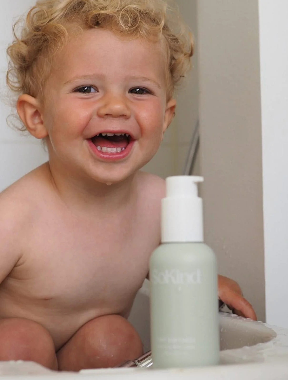 Baby in bad met de Tiny Softness Babylotion van SoKind op de voorgrond.