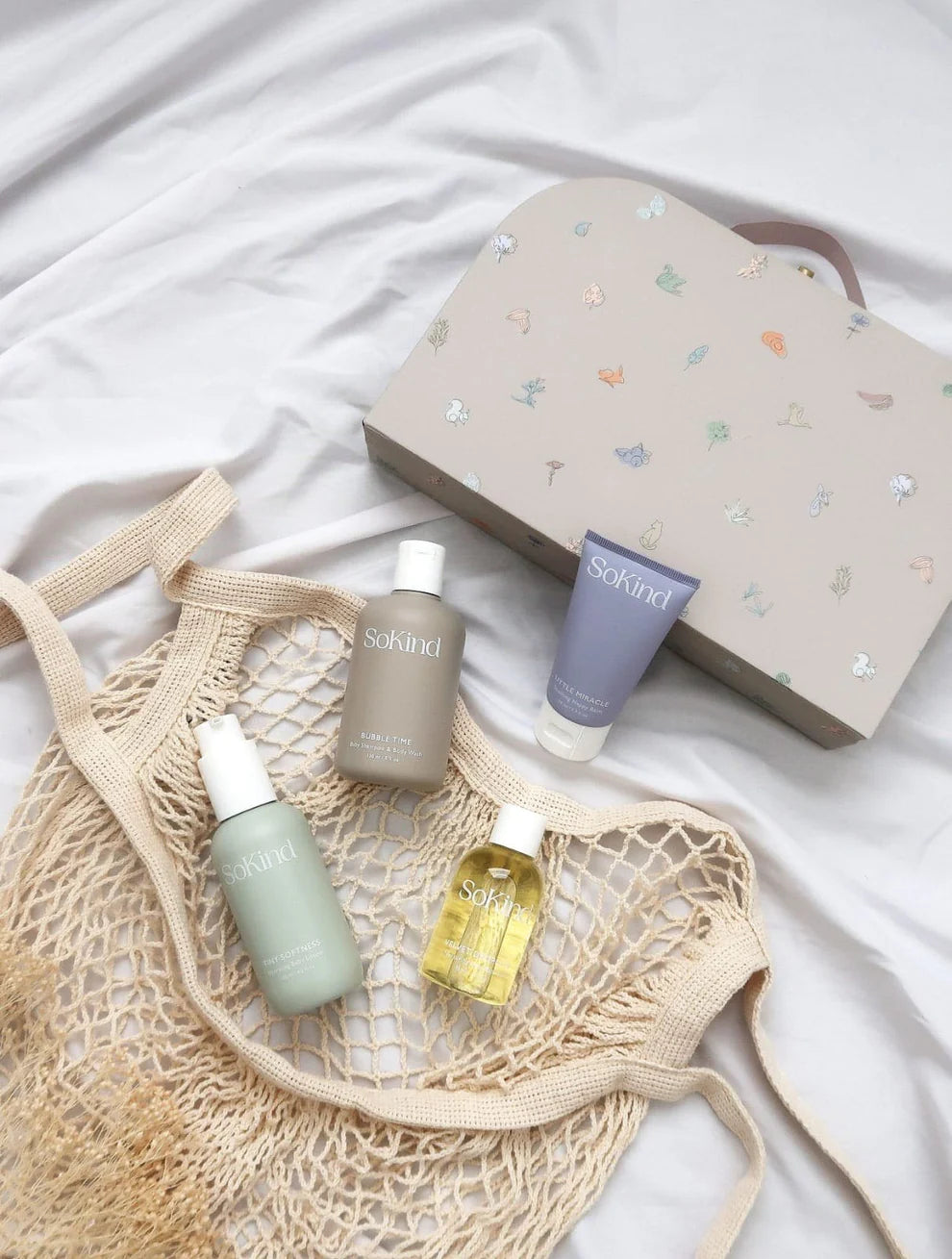 De vier SoKind producten voor de babyhuid die als Dear Baby Skin Care Kit worden verzonden, naast het koffertje waarin ze worden geleverd.