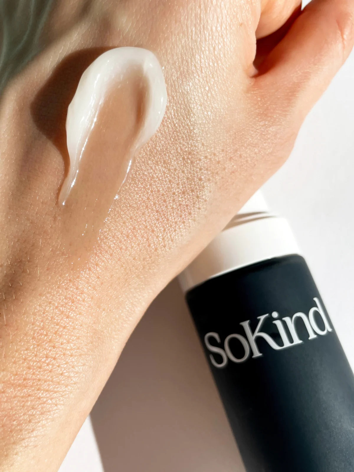 Close-up van een hand waar de Pure Kindness Repair Balm op is gesmeerd uit de Pregnancy Skin Care Kit van SoKind.