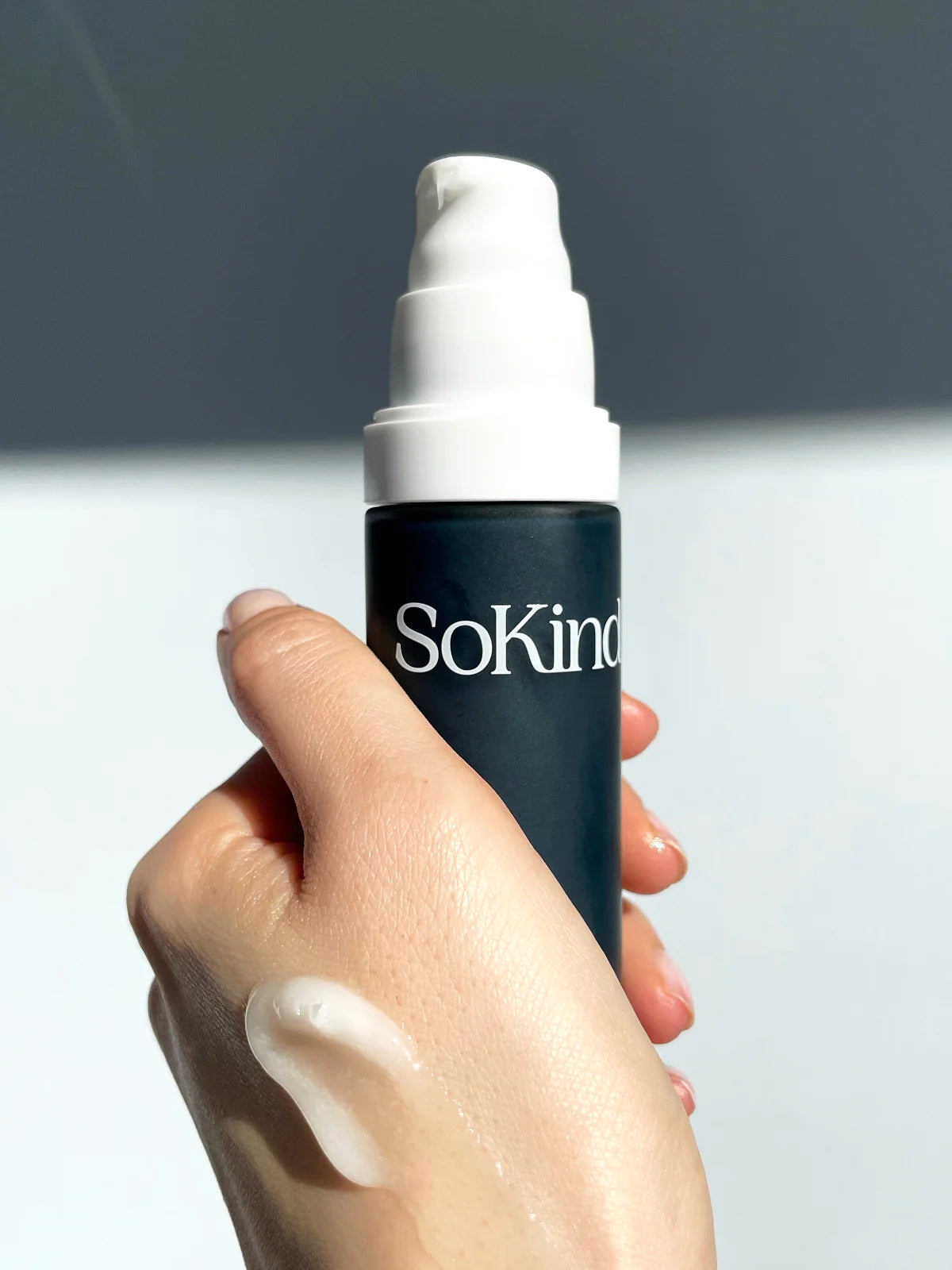 Hand die de Pure Kindness Repair Balm van SoKind vast heeft en waarop een beetje van de zalf is gesmeerd.