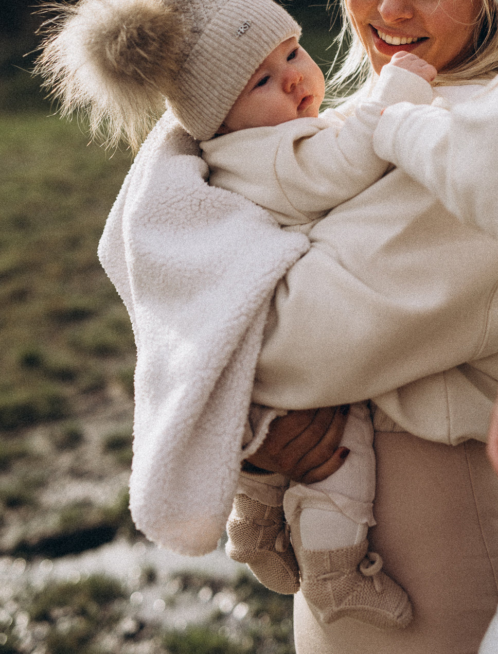 Mama houdt baby vast met dekentje