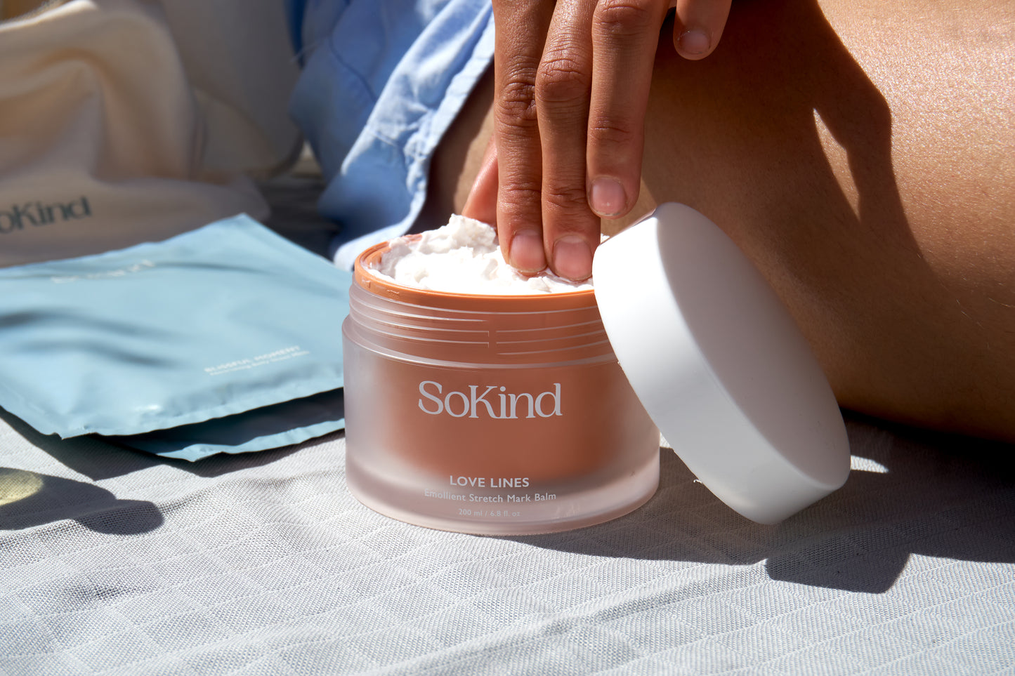 Hand haalt crème uit de Love Lines van SoKind, een van de producten uit de Pregnancy Skin Care Kit.