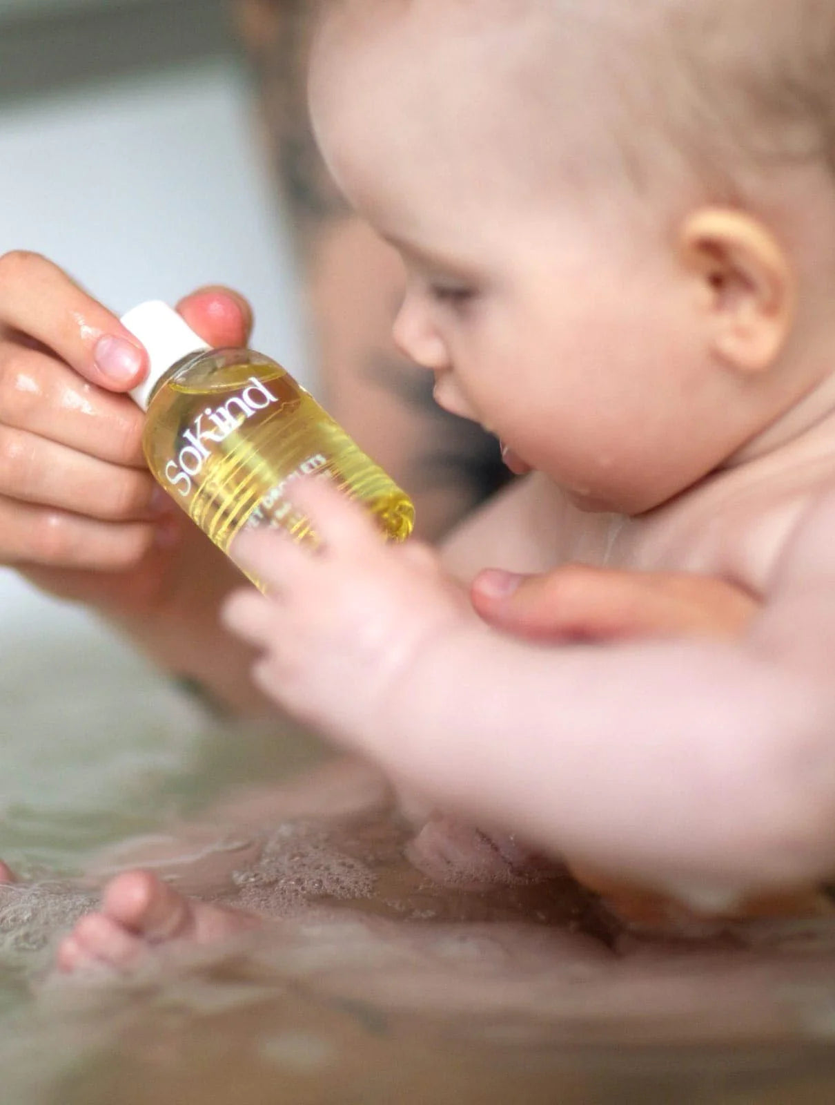 Baby in bad heeft de Velvet Droplets van SoKind vast.