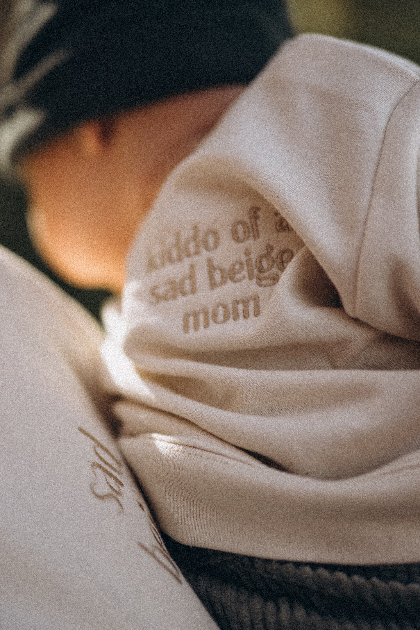 Close-up van de Kiddo of a Sad Beige Mom trui die een jongetje draagt.